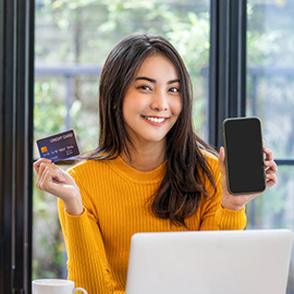 Woman holding her cell phone and credit card