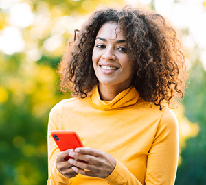 Young female smiling while holding her cell phone