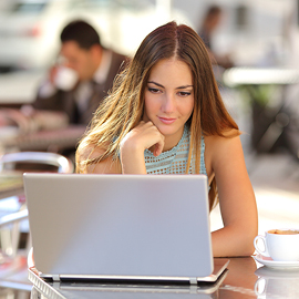 Young woman with her hand on her chin looking at her laptop