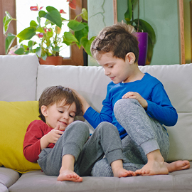 Two young boys sitting on their couch