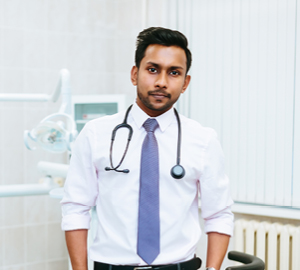 Doctor with a stethoscope around his neck standing in an examination room.