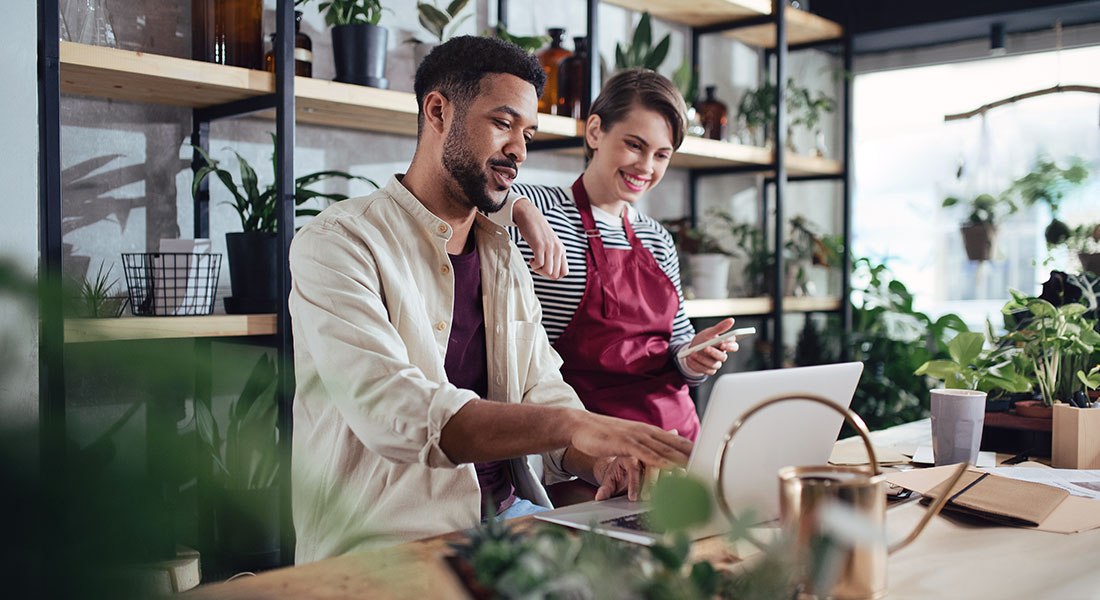 How to get a business loan - photo of a man and woman working in a plant shop looking at a laptop