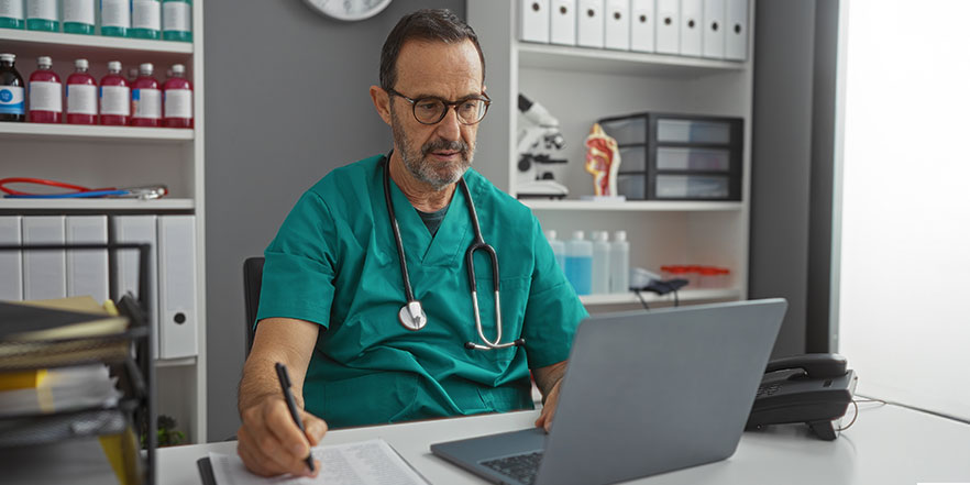Doctor looking at laptop - Buy a Business Loan