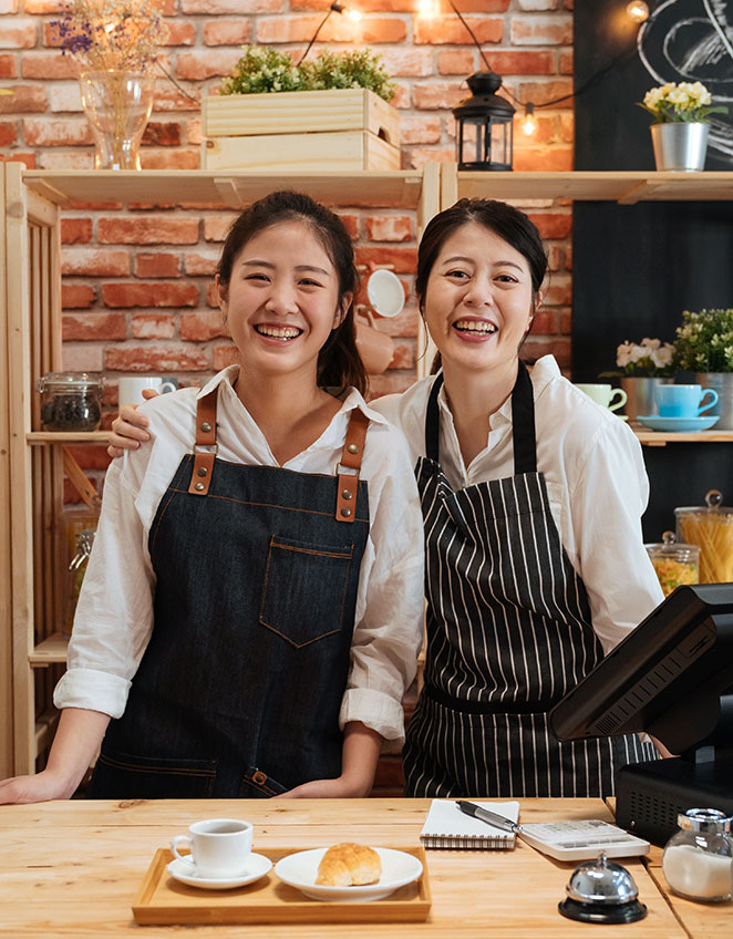 Shop owners behind the counter - Buy a Business Loan