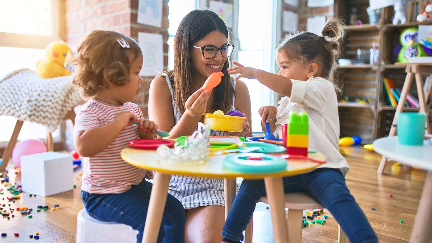 Childcare worker playing with children - Childcare Franchise Loans